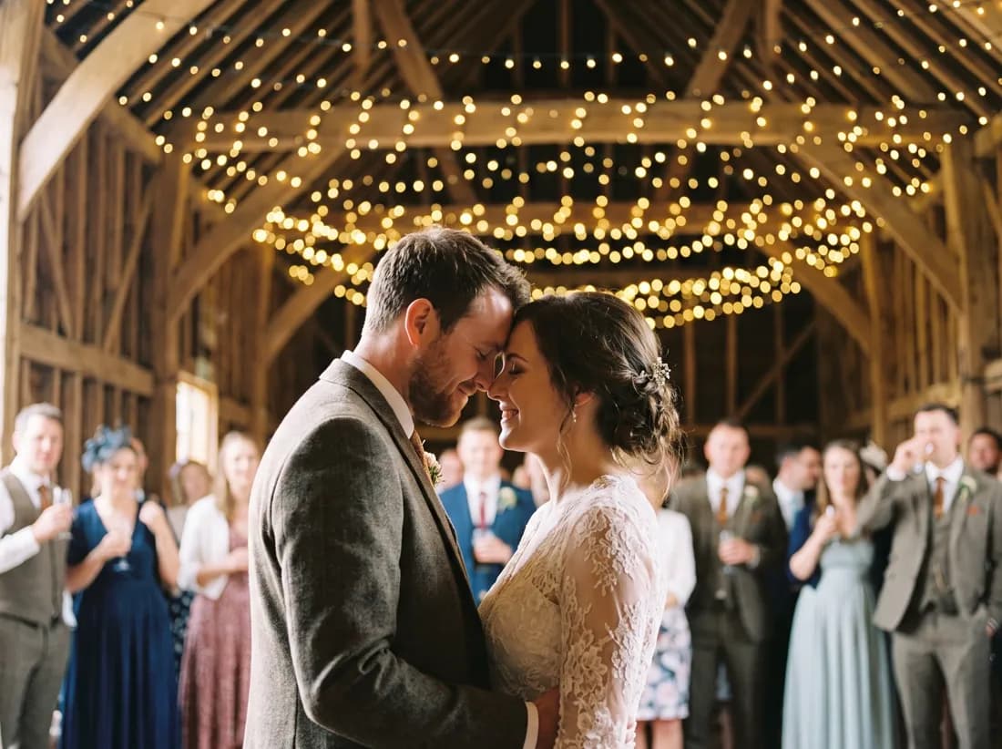 A bride and groom sharing their first dance under fairy lights, foreheads touching